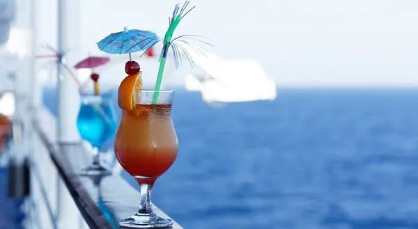 orange and blue cocktails on a cruise ship railing overlooking the water