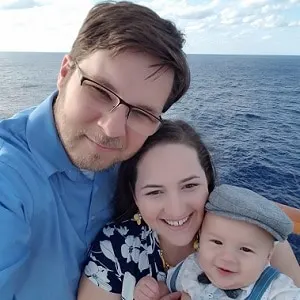 father, mother and son taking selfie picture on cruise ship overlooking water
